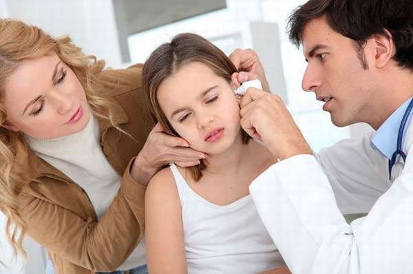 доктор закапывает девочке капли в ухо